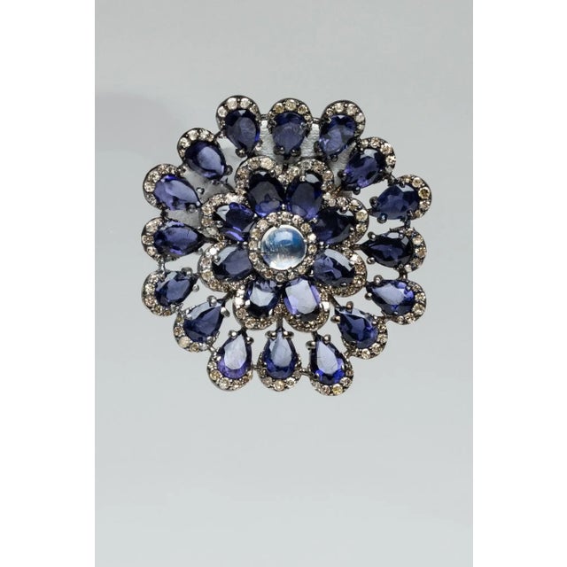 An impressive pair of stunning, flower motif stud earrings comprised of pear-shaped iolite gemstones with a round cabochon...