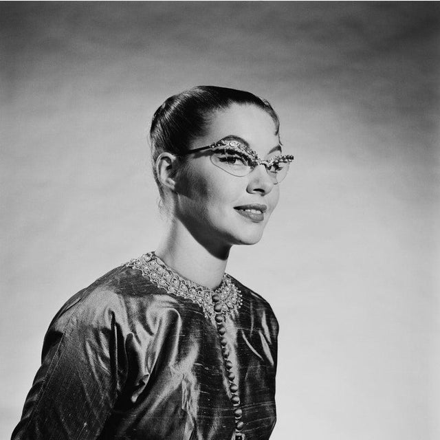Jewelled Specs A young woman wearing elaborate jewelled cat's eye spectacles with an embroidered Asian-style jacket, 1956....
