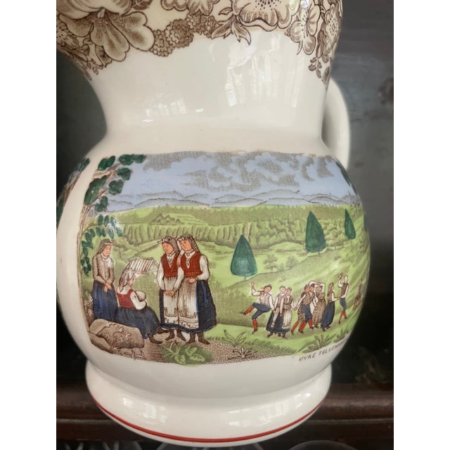 This vintage Norwegian Egersund Fayence Sofiemugge pattern pitcher depicts a village celebration scene and is entitled...