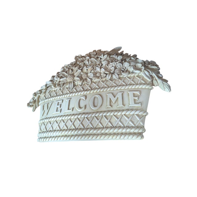 A Welcome Sign Plaque made of plaster and featuring a Basket of Flowers motif Has picture hanger affixed to backside