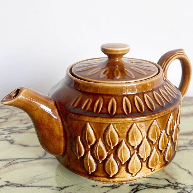 Amazing vintage English mid century pottery tea pot titles “Leaf”. Features a brown glaze throughout the surfaces.