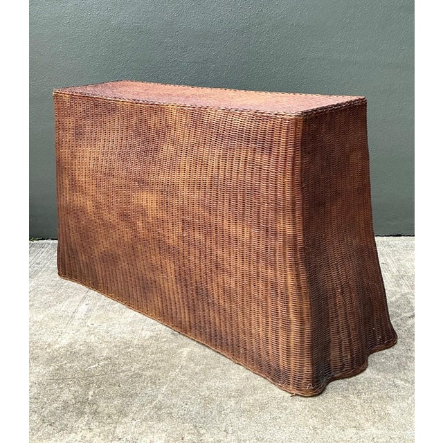 This vintage woven rattan console table is a sculptural and visually captivating piece, celebrated for its fluid “ghost”...