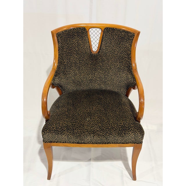 A striking vintage accent chair executed in the elegant French Regency style. The sculptural exposed wood frame features...