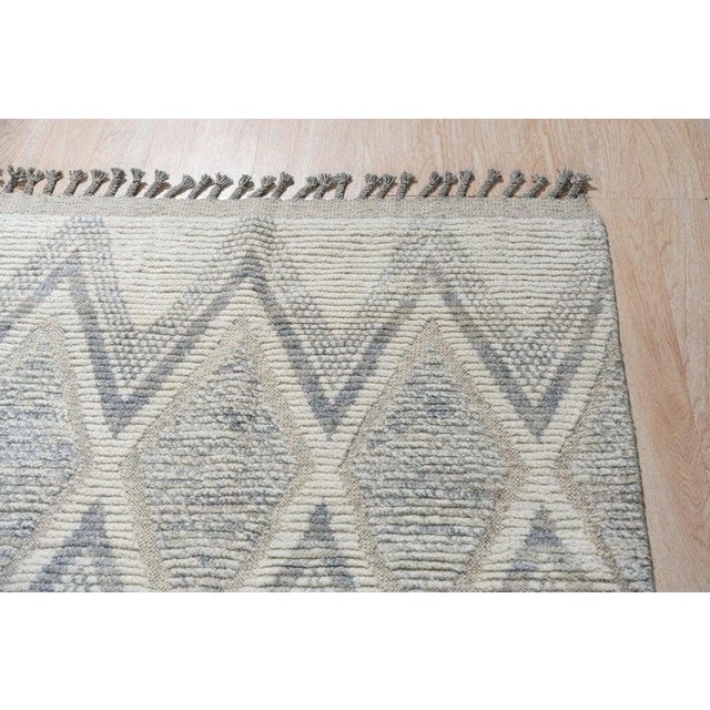 This hand knotted pile rug is crafted from wool and features a primary color palette of ivory, beige, cream, and white. As...