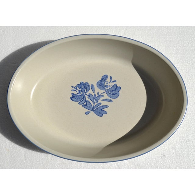 Late 1970s Pfaltzgraff Yorktowne Oval Baking Dish with a cream-colored, light gray stoneware body and a blue floral...