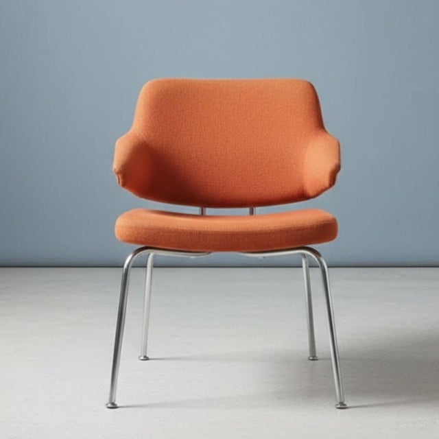 Stylish upholstered armchair from the 1970s, a representative example of mid-century modern design. The piece combines...