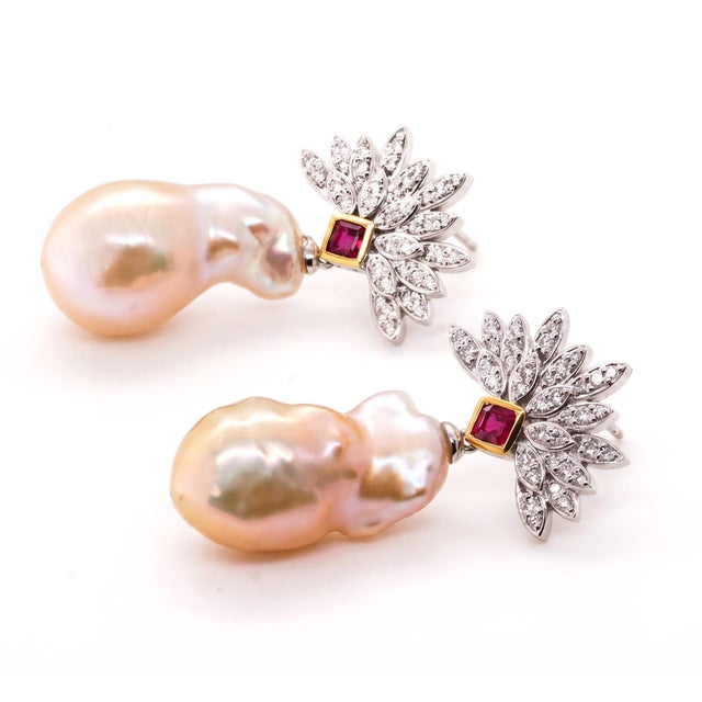 Vivid rubies, chosen for their stunning colour, form a striking focal point that anchors the composition. Their warmth...
