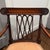 Classic neoclassical accent chair featuring a rich mahogany finish, carved fan motifs, fluted legs, and an elegant open-...