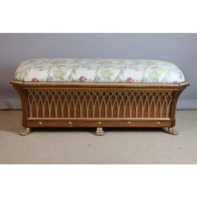 A walnut chest resting on six gilt bronze feet imitating lion's paws. The gilt bronze decoration, in an ogival shape, is...
