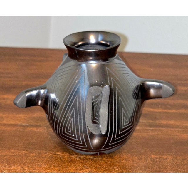 Celebrate the artistry of Northern Mexico with this striking blackware fish vase by Carolina of Mata Ortiz. Hand-coiled...