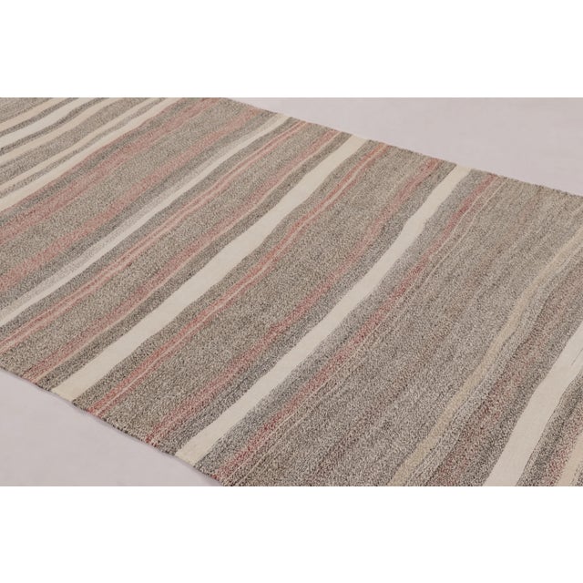 Made with handwoven wool circa 1950-1960, this 5x10 vintage flat-weave runner Kilim is a particularly serene and sought-...