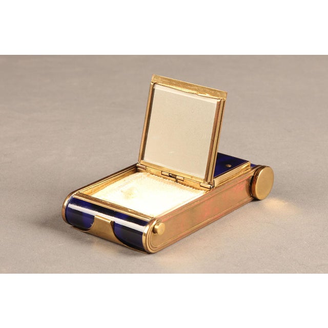 Circa 1920 ladies’ musical compact featuring blue enamel and gold-tone brass construction. The compact opens to reveal a...