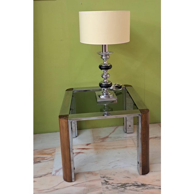 Italian-style side table, handcrafted from welded metal with a chrome finish and curved walnut wood, held together with...