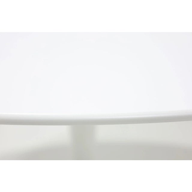 Discover timeless elegance with the iconic tulip table by Eero Saarinen for Knoll. Featuring a pristine white laminate...