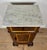 Elegant pair of Spanish nightstands featuring white marble tops, a single upper drawer, and lower cabinet doors with...