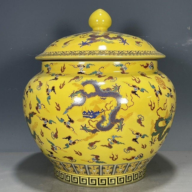 A striking Chinese porcelain ginger jar featuring a vibrant imperial yellow ground, hand-painted with dynamic dragons...