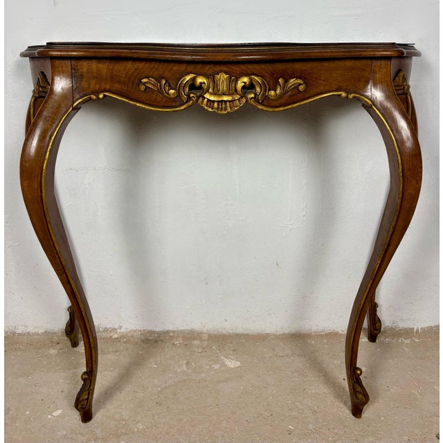 Elegant French Louis XV style console table crafted in wood with graceful curved lines and refined carved detailing. The...