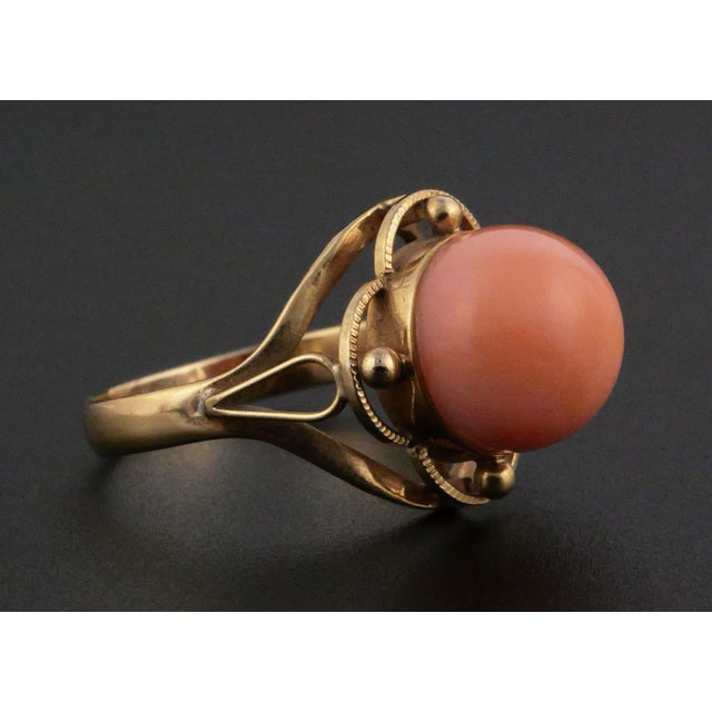 18K Gold and Angel Skin Coral Ring, distinguished by its warm blush-coral colored cabochon and graceful openwork setting....