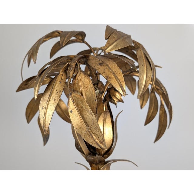 Table lamp designed by Hans Kögl in the 1970s. The sculptural light fixture features a palm tree design composed of gilded...
