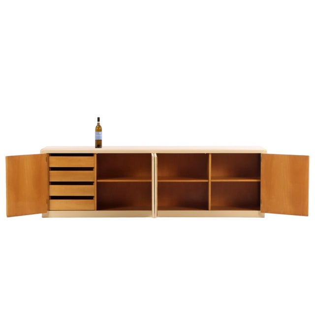 This low-profile Churba sideboard is painted a warm, neutral and offers a generous storage space. With a four parchment-...