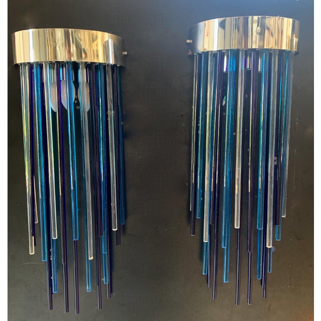 Lamps made with numerous colored glass rods attached to an iron frame, covered with a brass band. The glass shades range...