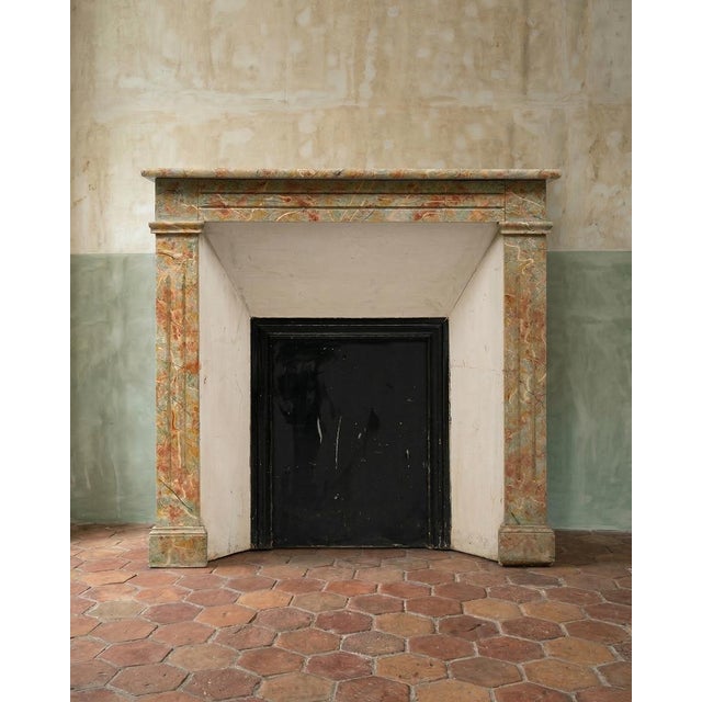 Lovely antique French "faux" wooden fireplace mantel, painted in a superb green marble with chestnut-red accents. We’ll...