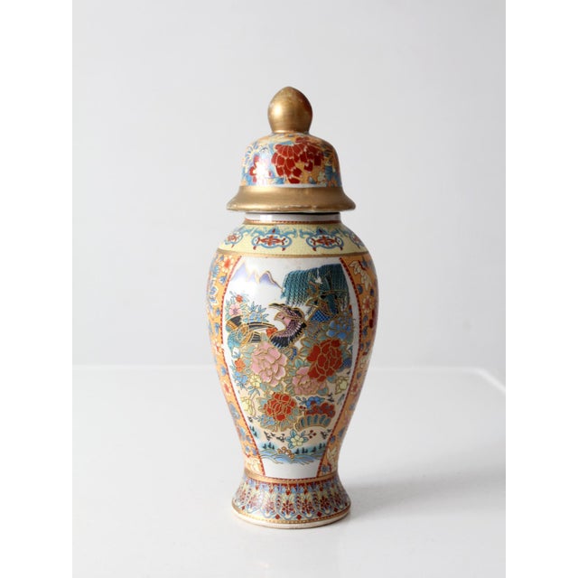 This vintage Chinese porcelain ginger jar from the mid-to-late 20th century features richly detailed Famille Rose-style...