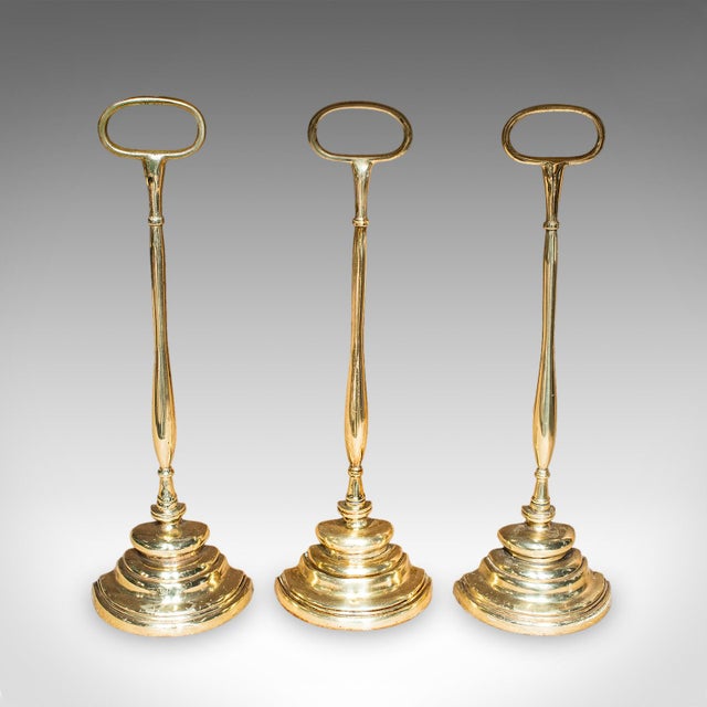 This is rare antique trio of door butlers. An English, brass demi-lune doorstop, dating to the Edwardian period, circa...