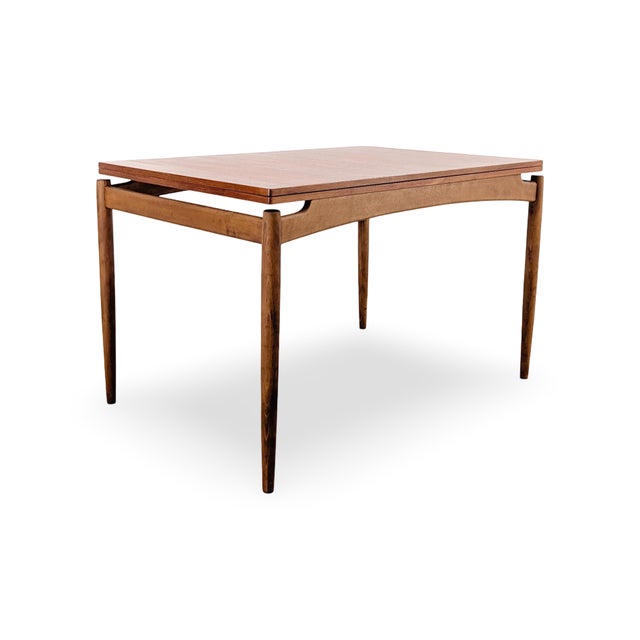 Beautiful vintage dining table from the 1960s for sale. Made in Denmark, this table features two hinges in the tabletop...