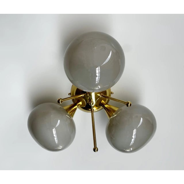 Italian flush mount with 3 gray pebble shaped Murano glass shades mounted on solid brass frame in lacquered polished brass...