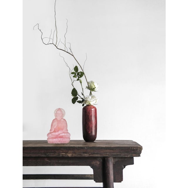 A finely hand-carved Buddha sculpture in luminous natural rose quartz. Seated upon a lotus-form base, the figure displays...
