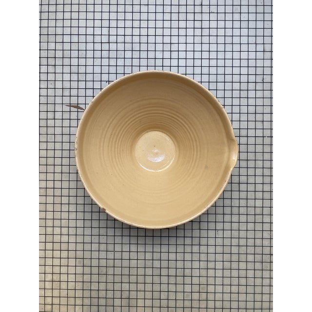 Large vintage French tian bowl in terracotta with a soft pale-yellow glaze and a small pouring lip. Traditionally used in...