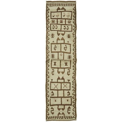 This exquisite runner rug is a rare example of tribal craftsmanship, hand-knotted by the women of the Herki tribe during...