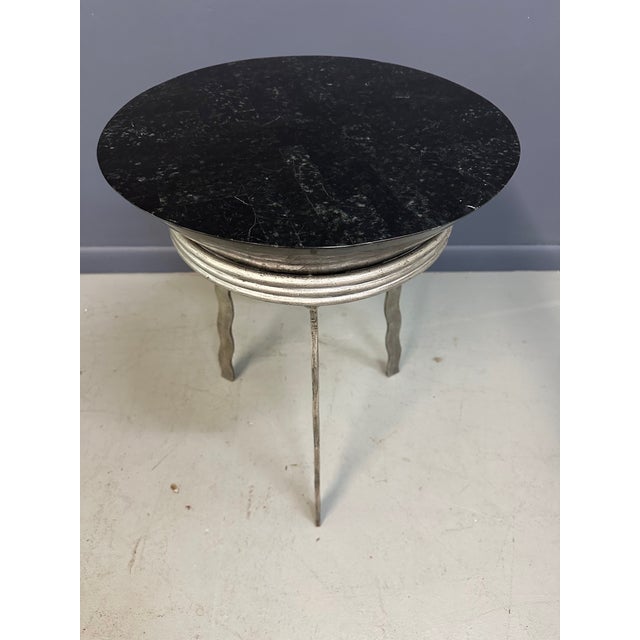 Bold and sculptural, this striking postmodern side table is a masterful expression of form and material in the style of...