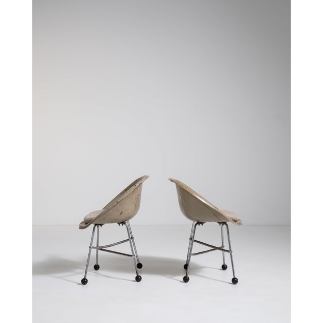 A pair of French mid-century accent chairs from circa 1960, combining a sturdy metal frame with upholstered cushioned...