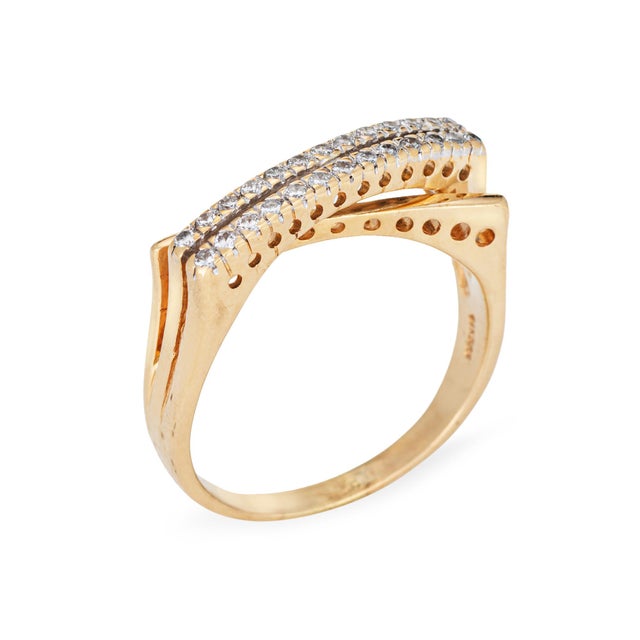 Stylish vintage diamond crossover ring crafted in 14k yellow gold (circa 1990s). 26 diamonds total an estimated 0.15...