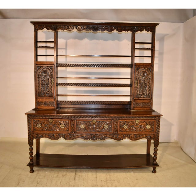 18th century Welsh dresser made from oak. The top has a lovely crown molding over a scalloped frieze, which is highly...