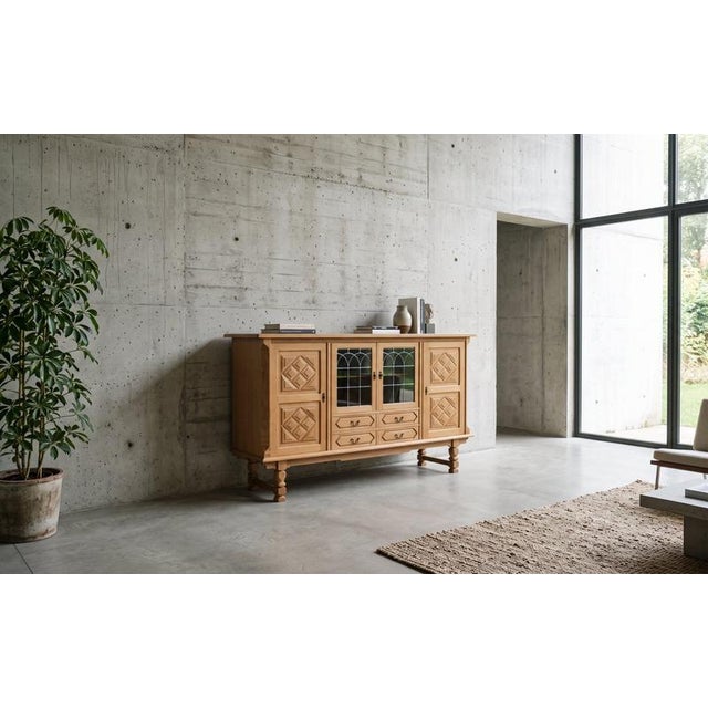 Danish Brutalist highboard in oak, dating from the 1960s. The cabinet features decorative leaded glass panels in colored...