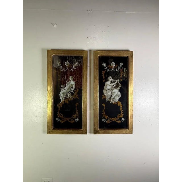 A refined pair of reverse-painted mirrored panels, exquisitely detailed with classical female figures draped in flowing...