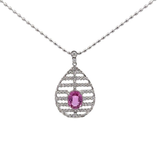 A striking pendant necklace featuring a teardrop design with a contemporary flair. The pendant showcases an oval pink...