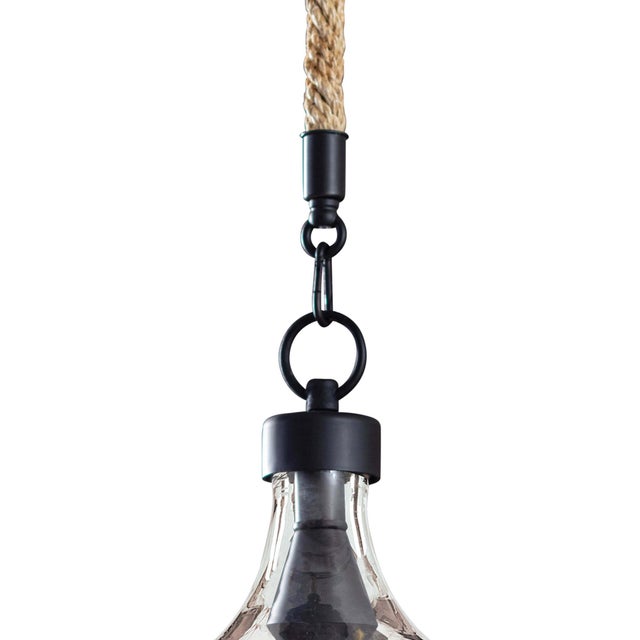 A subtly textured glass demi john bottle hangs from twisted jute rope to illuminate & add refreshing character over an...
