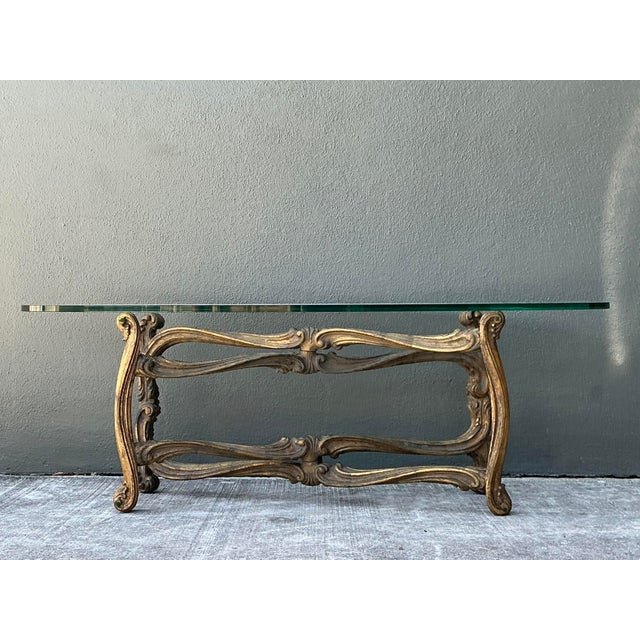 Exude timeless sophistication with this exquisite Hollywood Regency coffee table, designed in the esteemed manner of...