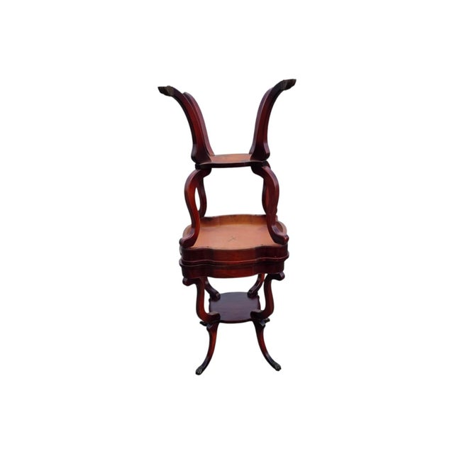 This product is a pair of 1940 Regency style leather top maple wood tables. These square tables feature a brown leather...