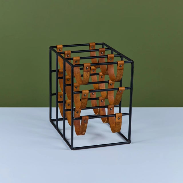 Arthur Umanoff wine rack, c.1950s, USA. The rack features a wrought iron frame with leather strapping to store up to nine...