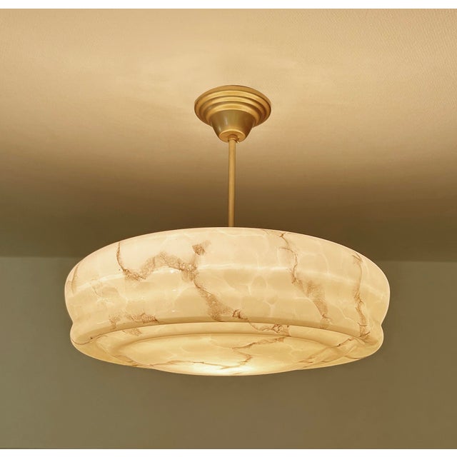 Large Art Deco pendant lamp featuring a flattened , stepped, vanilla light anber color mottled marble glass shade with...