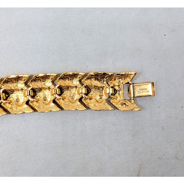 Circa 1993 goldtone "woven" look articulated link bracelet with fold over clasp. Marked "Napier" in script on the back of...