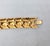 Circa 1993 goldtone "woven" look articulated link bracelet with fold over clasp. Marked "Napier" in script on the back of...