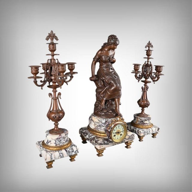 This Louis XVI style mantelpiece set comprises a central clock and a pair of matching five-light candelabra. The clock...