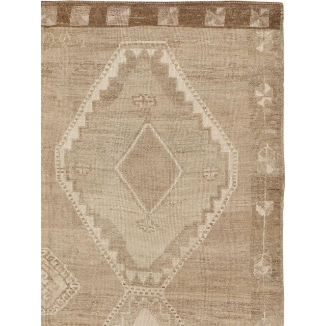 This Mid-20th century Turkish Anatolian gallery carpet presents a calm, spacious composition in a restrained palette of...
