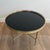 This beautiful round decorative coffee table is made of brass with a black lacquered glass top. It is a French work...